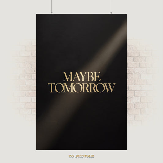 Poster with 'MAYBE TOMORROW' text on a black background, hanging on a white brick wall.