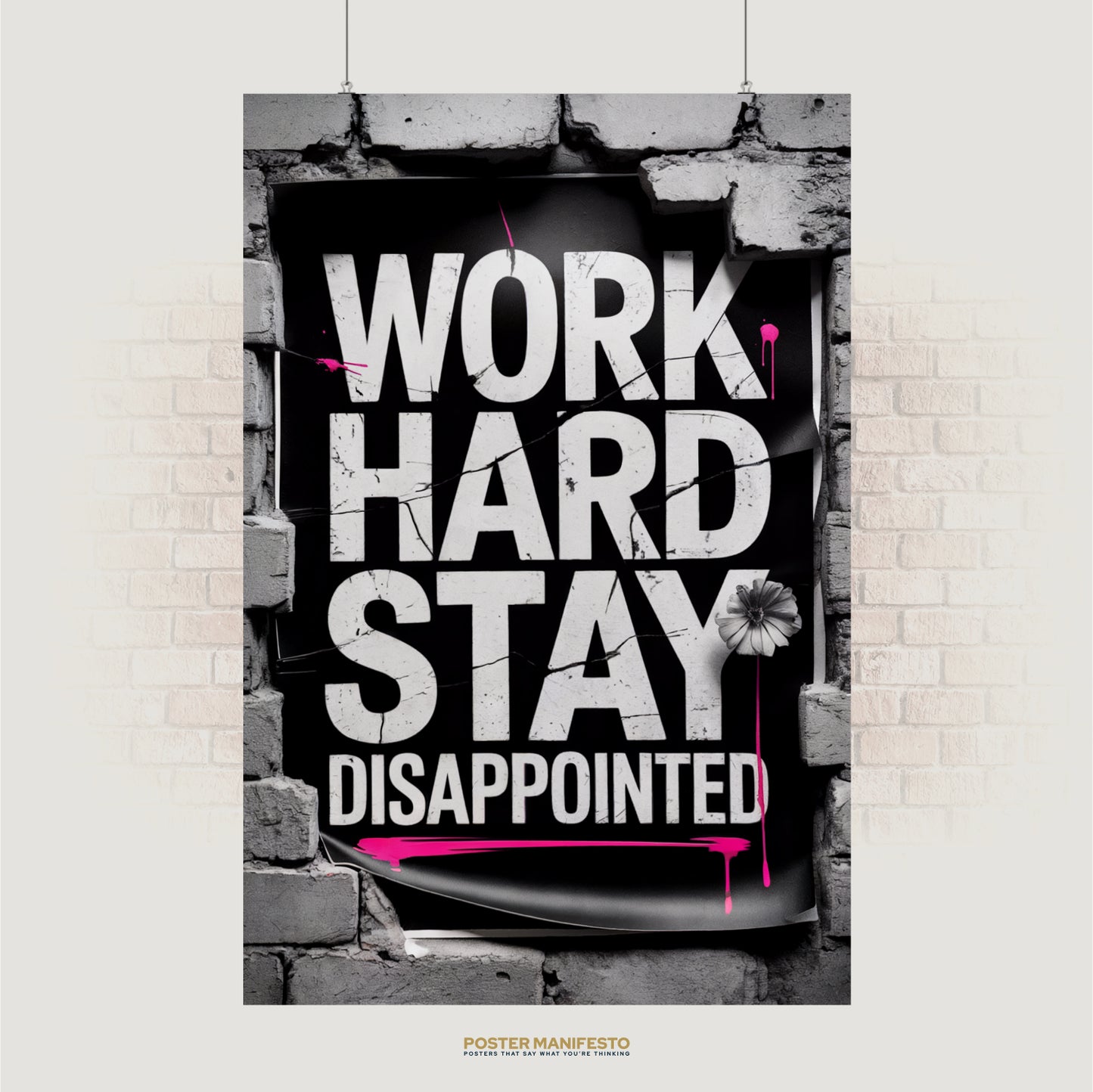 Bold typography poster reading “Work Hard Stay Disappointed” with pink paint splashes and brick frame