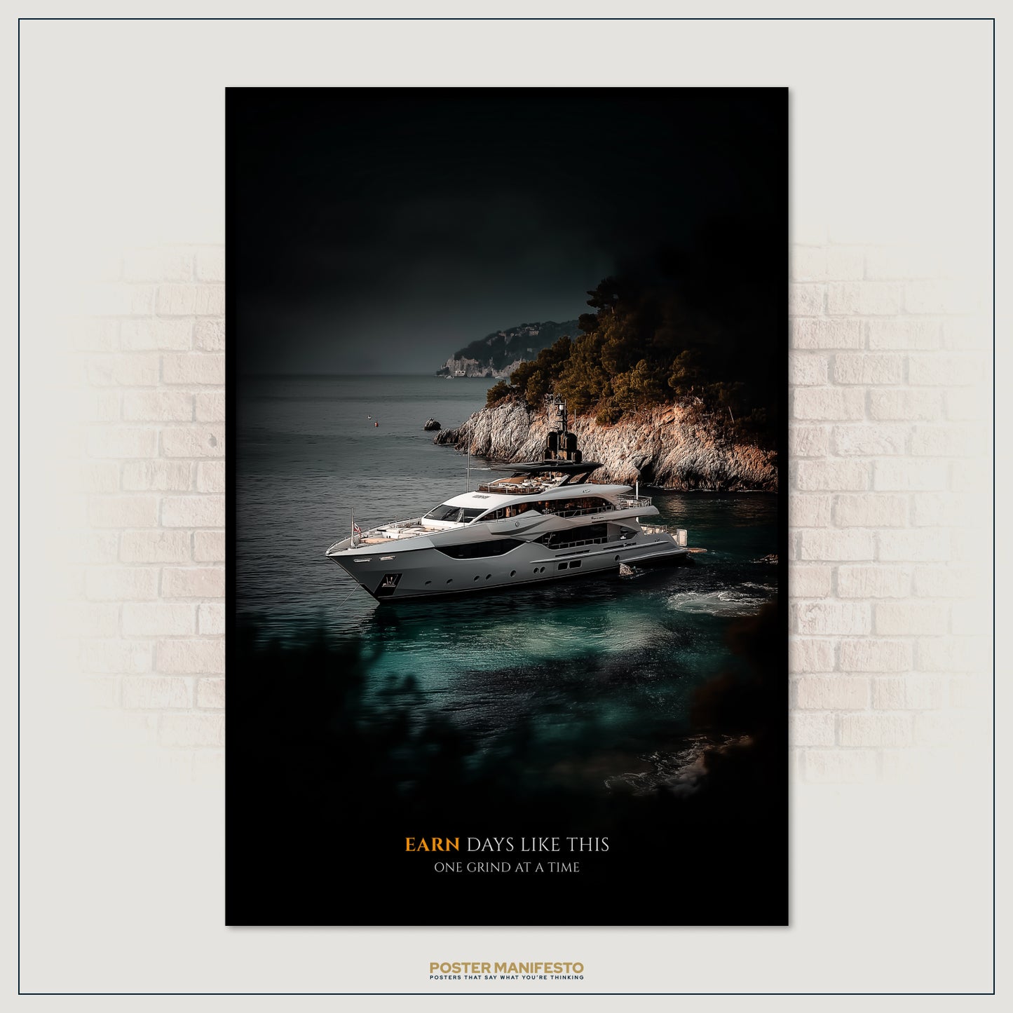 Framed poster of a yacht on the water with a mountainous island in the background, displayed on a brick wall.
