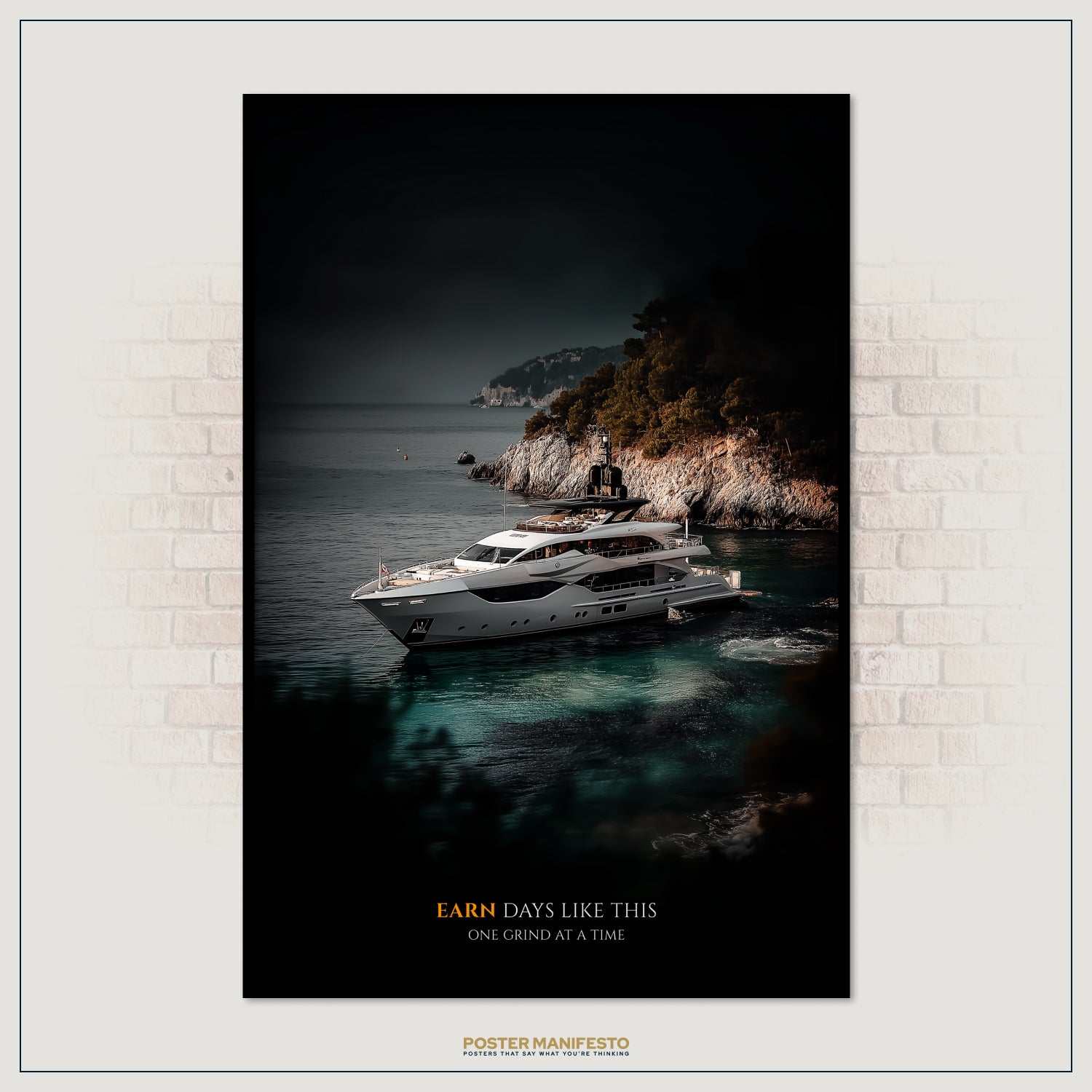 Framed poster of a yacht on the water with a mountainous island in the background, displayed on a brick wall.