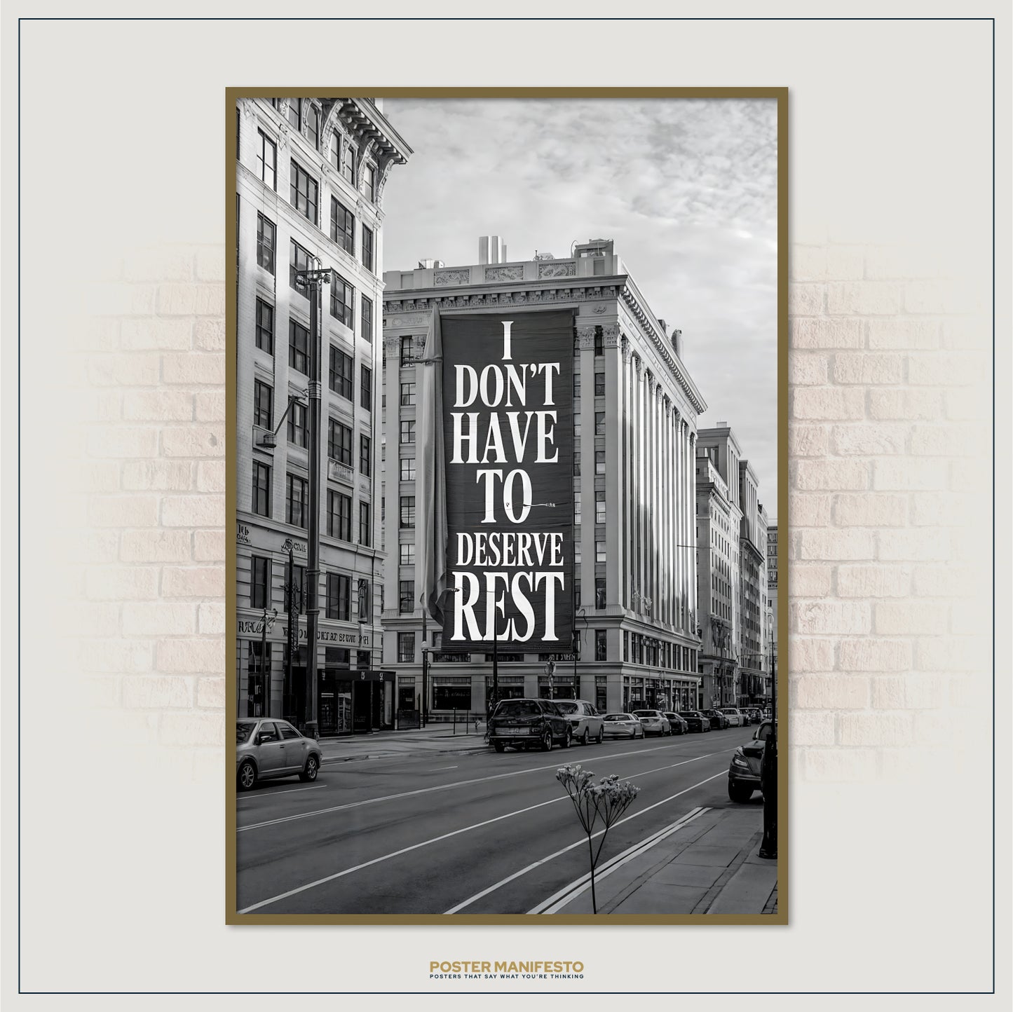 Framed poster with a city street scene and motivational quote on a brick wall.