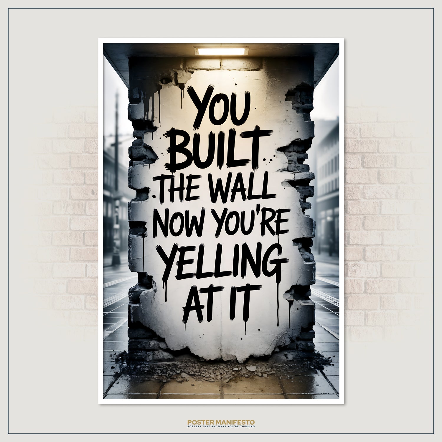 Bold urban graffiti quote in dripping black letters on a distressed wall, reading “You Built The Wall. Now You’re Yelling At It,” illuminated by a single overhead light.