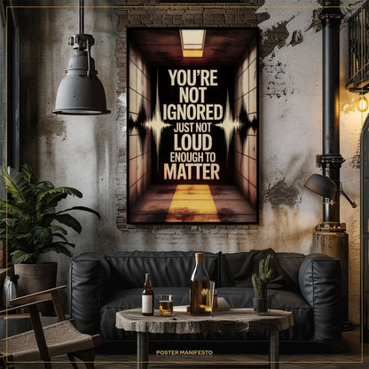 Living room with a dark couch, coffee table, and motivational poster on the wall.